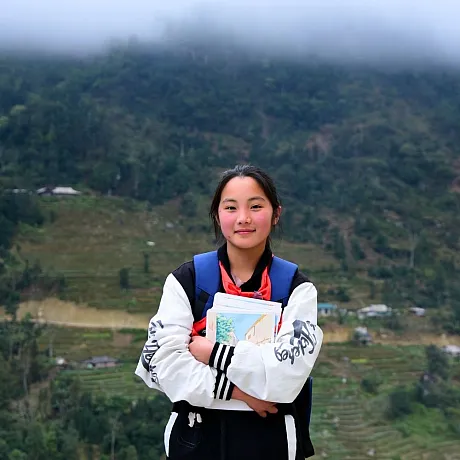 Skolejente med fjell i bakgrunnen i Vietnam