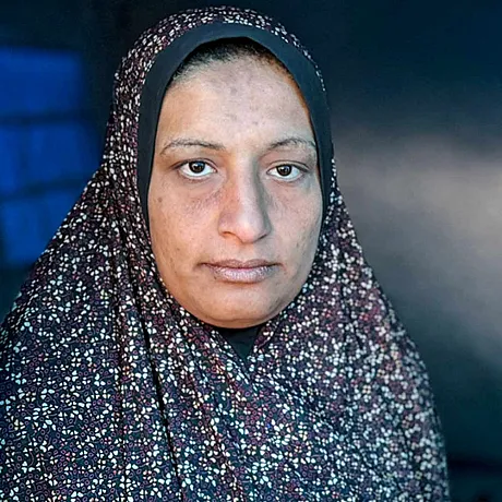 Portrett av Suhad (kvinne) som står i teltåpning i Gaza