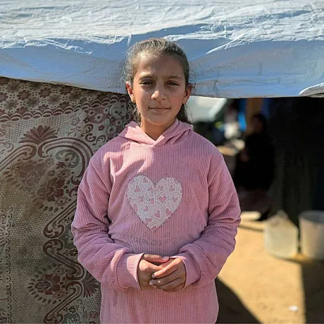 Jente står utenfor teltet hun bor i i Gaza.
