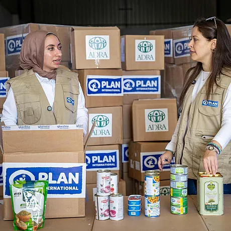 Kvinner som pakker Plan-esker med mat og nødhjelp