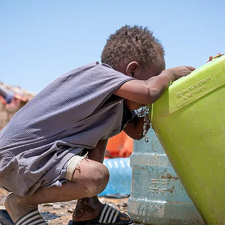 Gutt drikker vann i Sudan