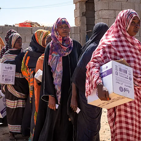 Kvinner venter på utdeling av hygeniepakker i Sudan