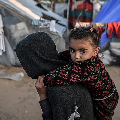Bror som bærer søsteren sin på ryggen i Gaza.