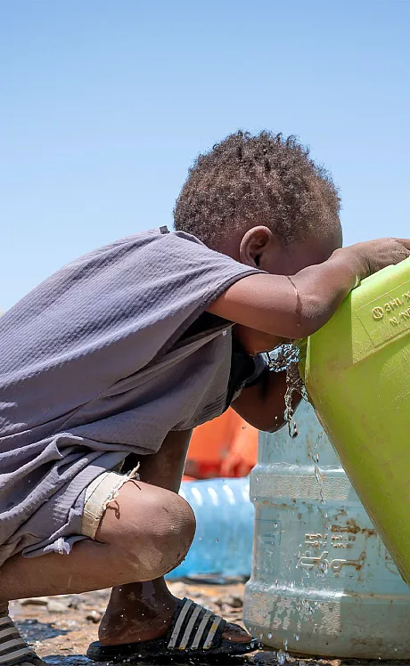 Gutt drikker vann i Sudan