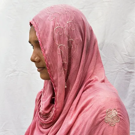 Jente skjult bak et rosa sjal.