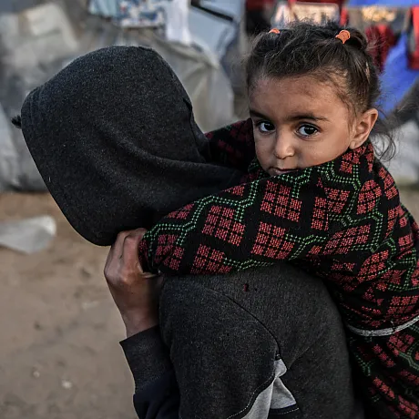 Jente bæres på ryggen av et søsken i Gaza.