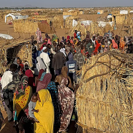 Flyktninger går mellom telt i flyktningeleir