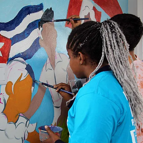 Naimar fra Venezuela maler på vegg i Peru