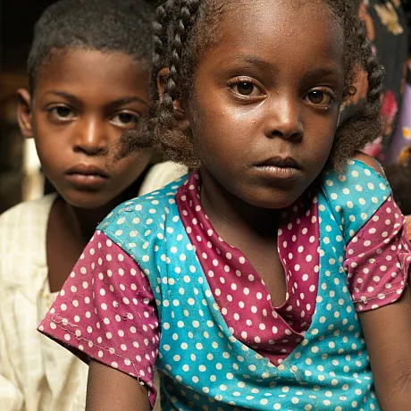 Ei jente fra Sudan sammen med andre barn.