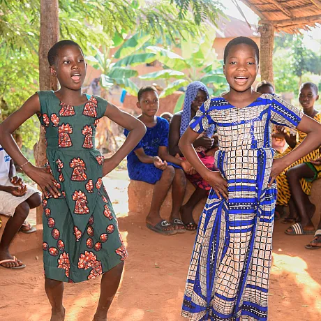 To jenter danser med venner rundt omkring i Benin