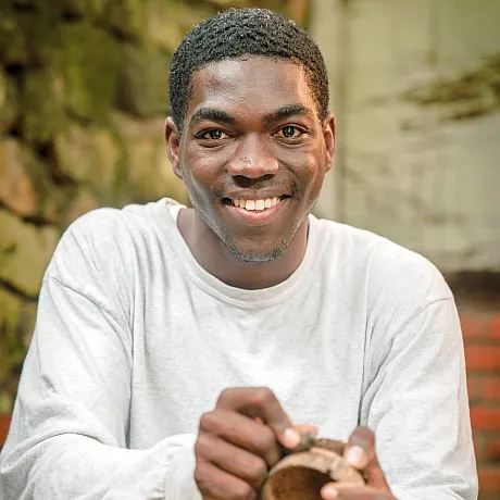 Ung mann med hvit genser driver med håndverk i Dominikanske republikk.