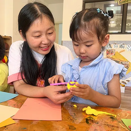 Lærer og jente pussler på forskolen i Kina.