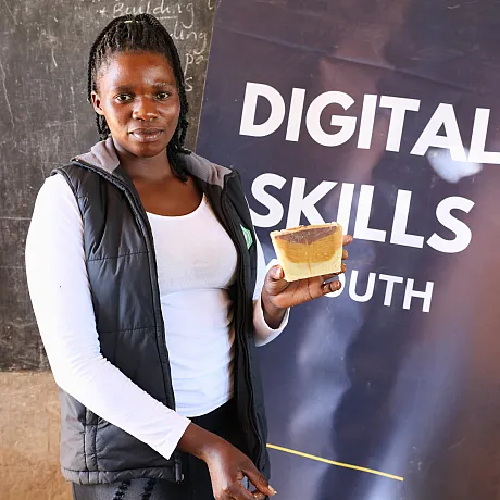 Ung kvinne står forran en roll-up om Digital skills.