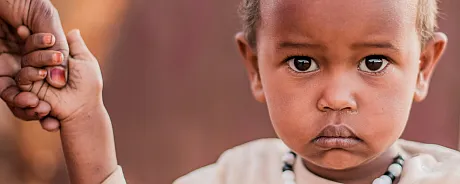 Gutt fra Somalia holder en voksen i hånden.