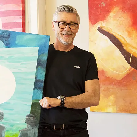 Kunstner Rino Larsen viser frem ett av verkene sine.