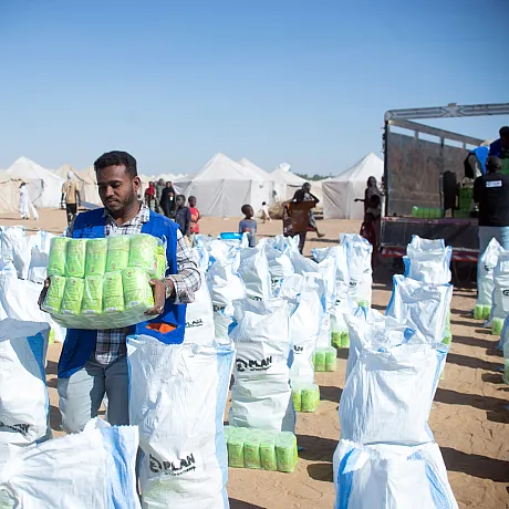 Mann som bærer mat som skal deles ut til flyktninger i Sudan.