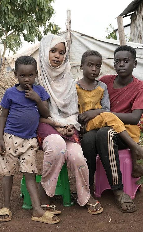 Storesøster og tre brødre utendørs i flyktningleir i Etiopia.
