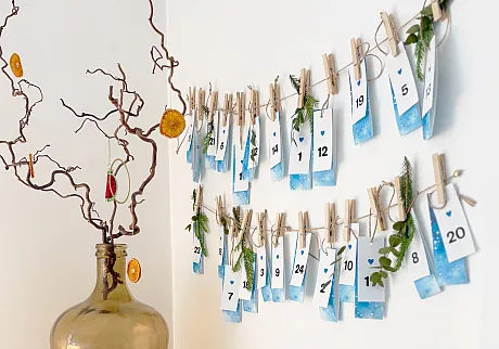 Plans gratis julekalender hengt opp på veggen hjemme hos en familie.
