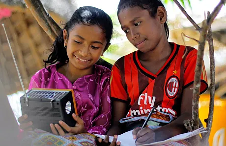 Barn fra Indonesia følger undervisningen via radio.