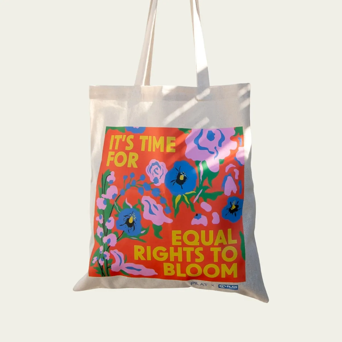 Gaver med mening: Handlenett "It's time for equal rights to bloom". Hvit bakgrunn. Foto.