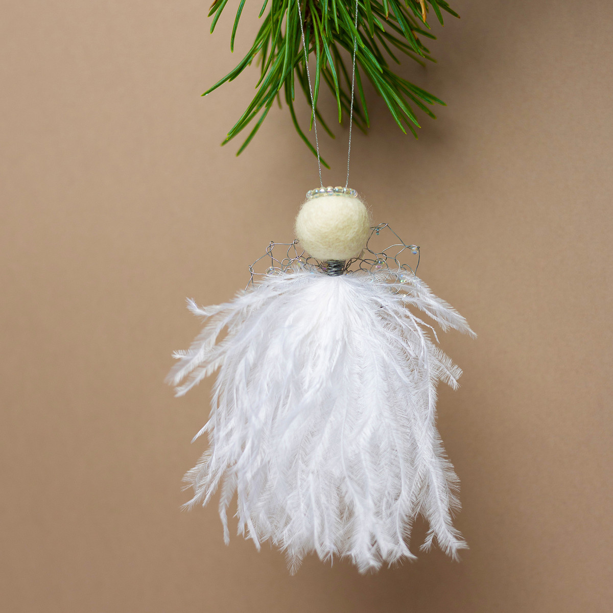 Gaver med mening: Juleengel med hvite fjær og perlemorfargede perler. I miljø.