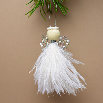 Gaver med mening: Juleengel med hvite fjær og perler i miljø. Foto.