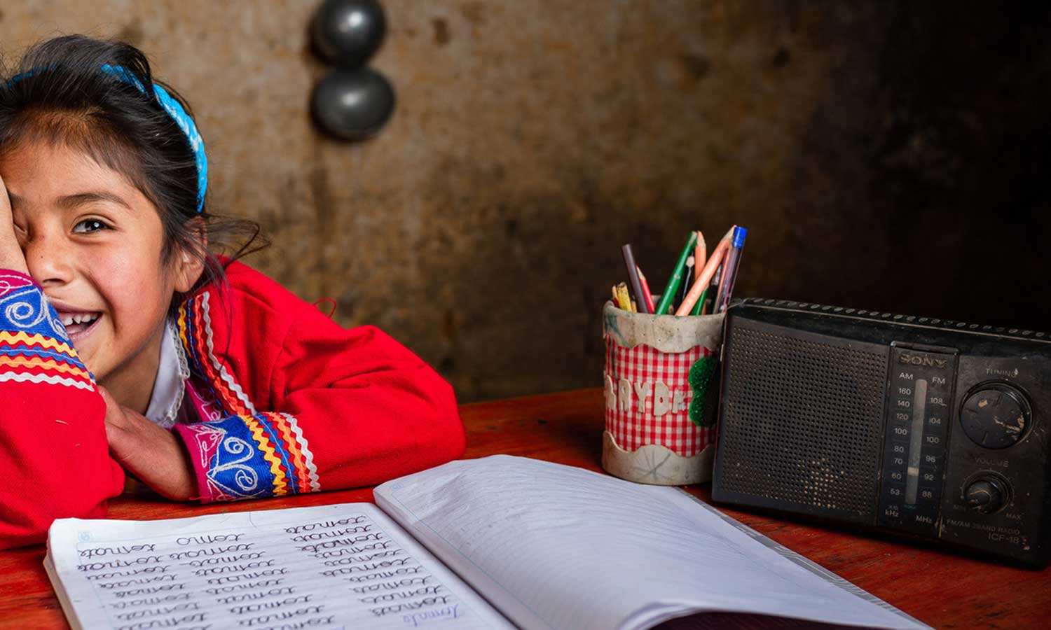 Zenaida (6) fra Cusco i Peru bruker radioen for å gjøre skolearbeidet sitt.